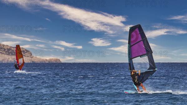 Sky exchanged, windsurfers gliding on calm sea with bright sky in the background, windsurfers,