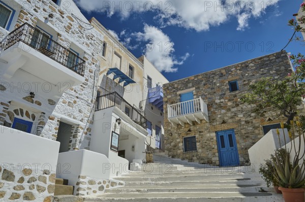 Stone and plaster houses on a picturesque staircase with a bright blue sky in the background,