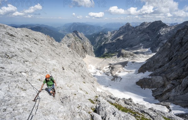 Mountaineer with helmet in a secured via ferrata, Zugspitze via ferrata, ascent to the Zugspitze,