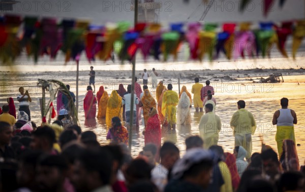 Hindu devotees perform rituals as they offer prayers to the Sun god in the bank of Brahmaputra
