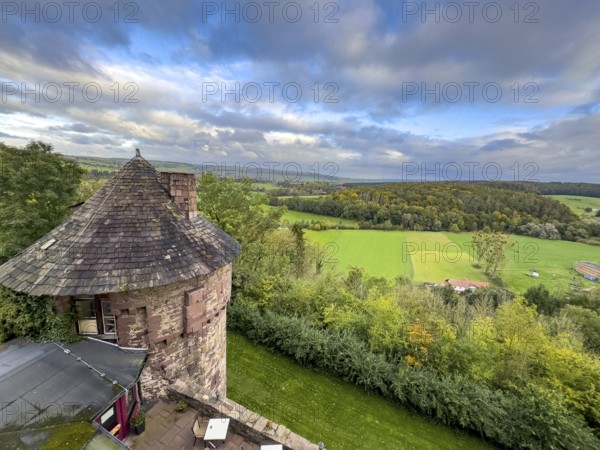 View from Trendelburg Castle to shingle roof of castle tower in the foreground behind green valley