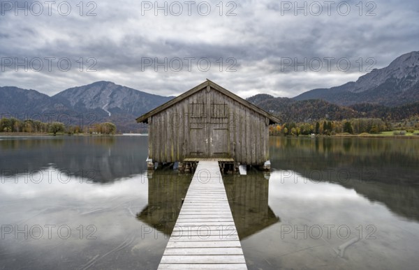Boathouse in the lake, Lake Kochel in autumn with reflection, Upper Bavaria, Bavaria, Germany,
