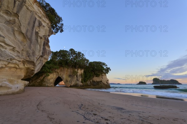 Sandy beach beach with rock and cave views, surrounded by calm seas and clear skies, Cathedral