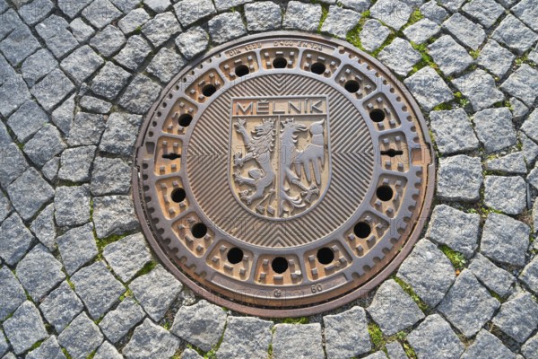 Round manhole cover with coat of arms on cobblestones, manhole cover, Melnik, Melnick, Central