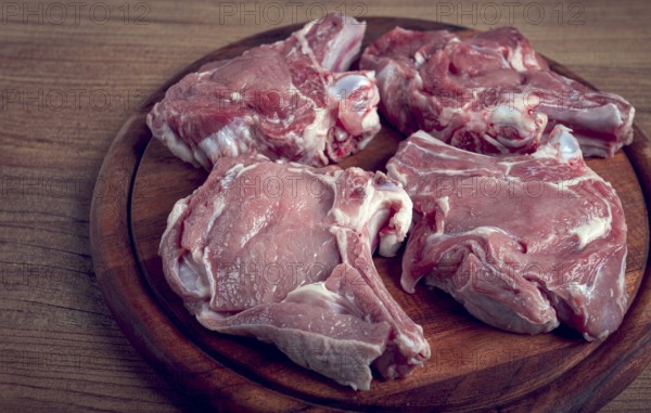 Raw calf meat, meat on the bone, meat for barbecue, cutting board, top view