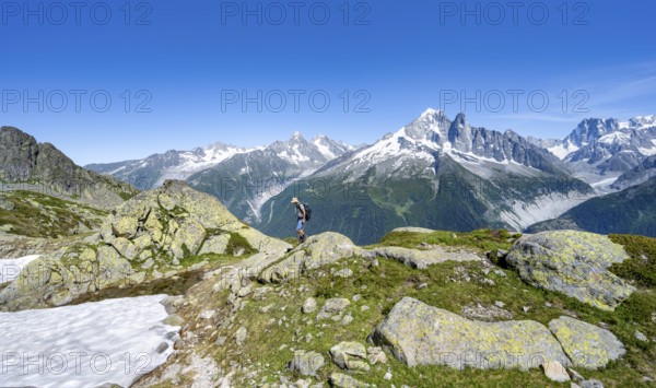 Mountaineer on a hiking trail in front of a mountain landscape, view of mountain peak Aiguille