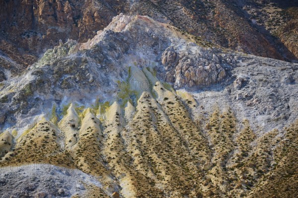 Complex geological formations in a volcanic landscape, characterised by rough stone and yellow