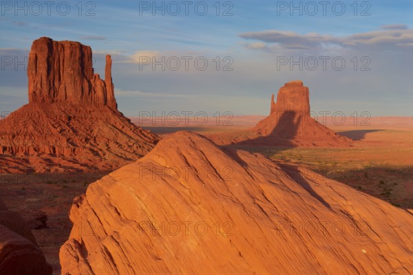 Monument Valley with majestic red sandstone formations in the desert under a clear sky in sunlight,