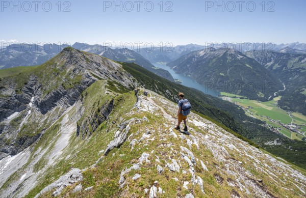 Mountaineer on the summit ridge of the Unnütz, behind Achensee and summit of the Seekarspitze