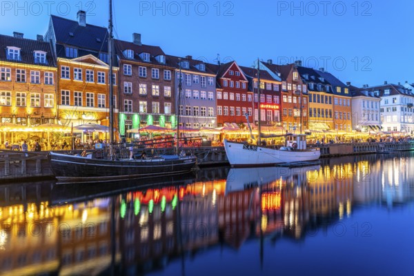 Colourful houses, restaurants and historic ships on the Nyhavn canal and harbour at dusk,