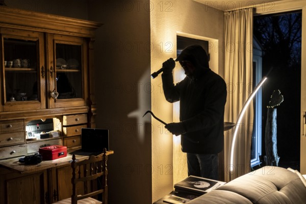 Symbolic image of a burglary, perpetrator has broken into a flat from the garden side and is