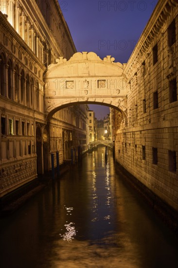 View from 'Ponte della paglia' on the bridge 'Bridge of Sighs' over a waterway at the blue hour in