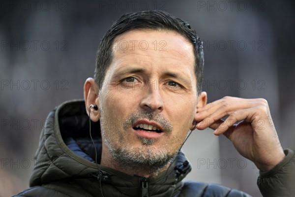 Coach Dino Toppmöller Eintracht Frankfurt SGE Portrait puts headphones in his ears for the