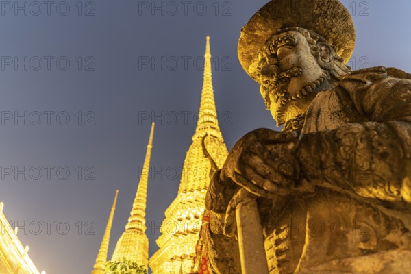 Giant Farang Guard and Chedi of the Buddhist temple Wat Pho at dusk, Bangkok, Thailand, Asia