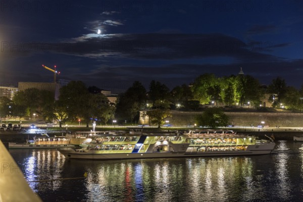 City view with Elbe in the evening, steamer departure, illuminated silhouette at the blue hour,