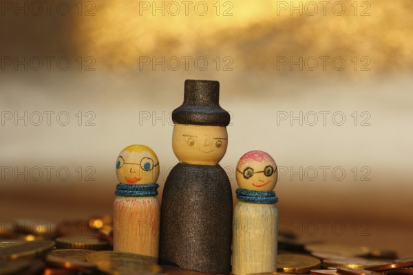 Three wooden cones standing in euro coins, North Rhine-Westphalia, Germany, Europe