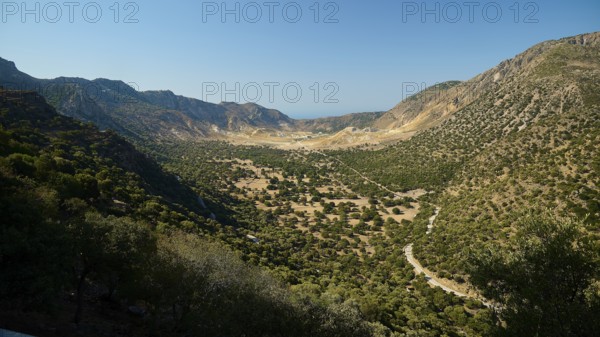 Wide valley with wooded slopes and mountains under a clear sky, volcanism, volcanic island, access