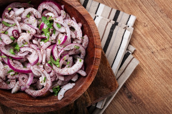 Chopped red onion, with sumac and herbs, in a bowl, pickled Spanish onion, close-up, top view