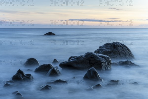 Rocks on the beach of Playa del Inglés. Sunset. Sea and waves. Long exposure. Valle Gran Rey, La