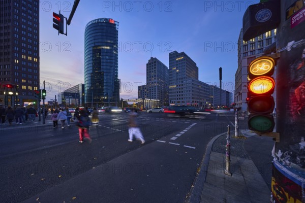 Cyclist traffic light, pedestrian crossing, pedestrian with motion blur and railway tower at blue