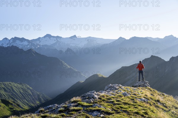Hiker enjoying the mountain panorama in the morning, Venediger group, behind Dreiherrenkopf,