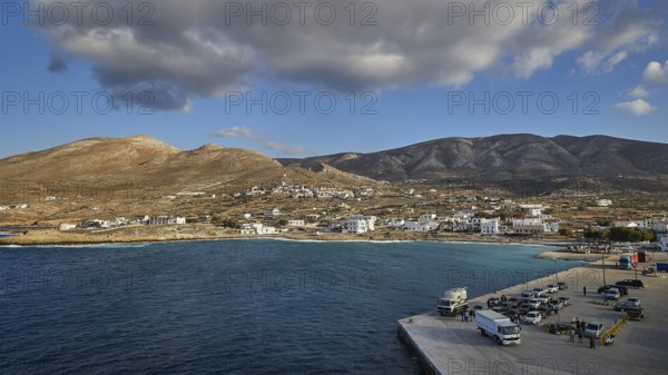 Coastal village with buildings and a harbour in the foreground, surrounded by mountains, Kassos