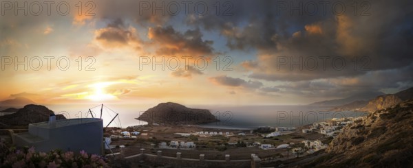 Sweeping panoramic view of the coastal landscape from the town of Arkasa and windmill at sunset,