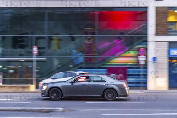Car at night in front of urban surroundings with modern architecture, pull-along. Stuttgart,