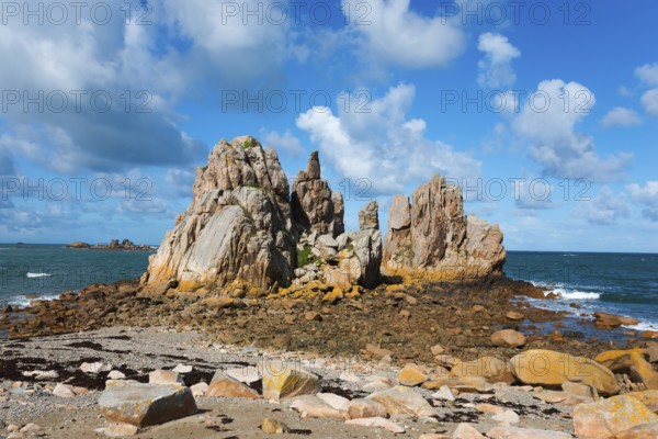 Rock formations on a sunny coast under a blue sky with clouds, Plage de Pors Scaff, Plougrescant,