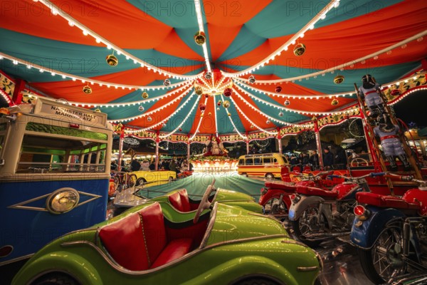 Lively carousel with colourful lights and children's vehicles, Christmas market Ludwigsburg,