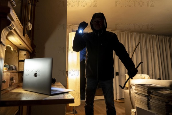Symbolic image of a burglary, perpetrator has broken into a flat from the garden side and is