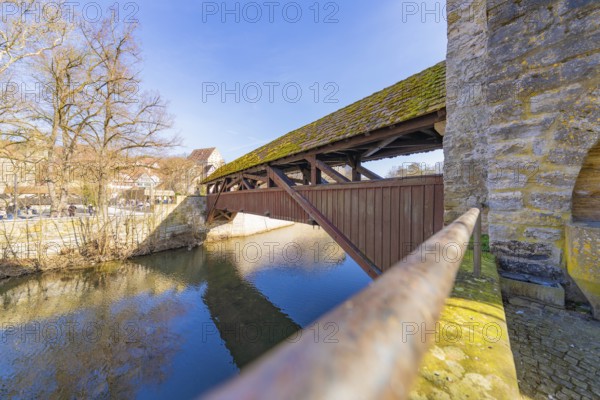 Wooden bridge over a river with stone wall and railing, Schwäbisch Hall, Germany, Europe
