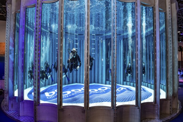 Diver swims dives in diving tower in exhibition hall 12 of Messe boot, on the ground lettering boot