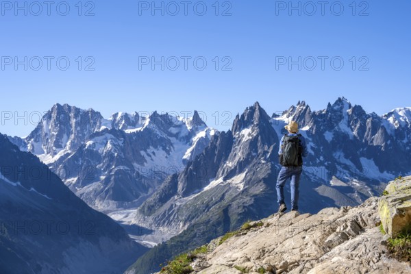 Mountaineer on a hiking trail in front of a mountain landscape, view of the mountain peaks Grandes