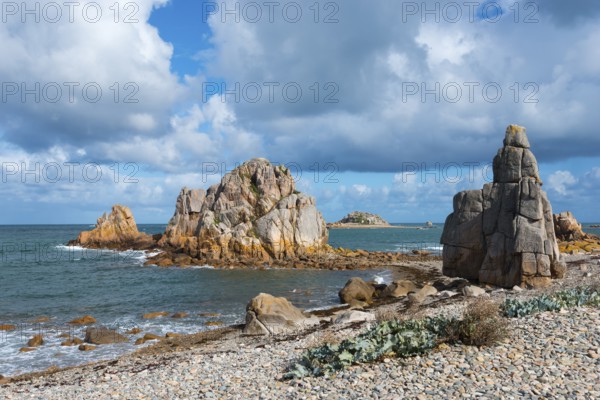 Rough coastal landscape with large rocks and calm sea under a cloudy sky, Plage de Pors Scaff,