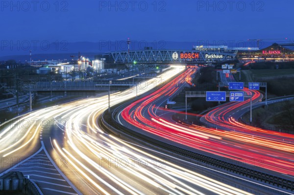 A8 motorway at Stuttgart Airport in the evening. Heavy traffic, lanes of light. Modern architecture