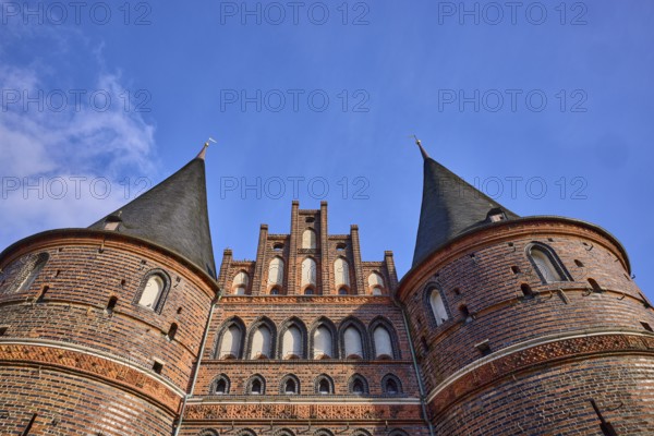 City gate, historic brick building, round towers with slate roof, gable, frog perspective,
