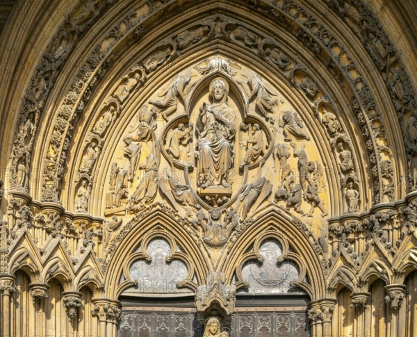 Stonework carvings God in heaven above doorway, The Judgement Porch, Lincoln Cathedral, Lincoln,