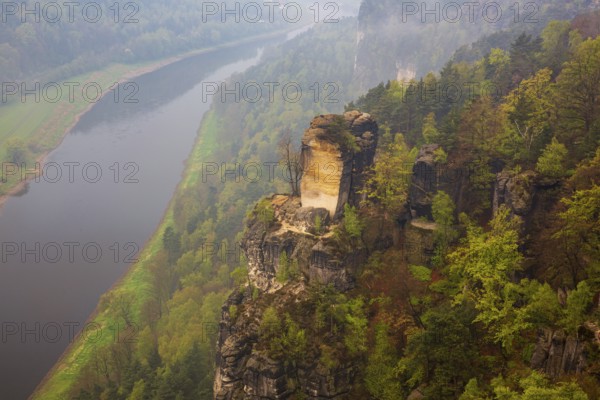 The bright lit Wartturm above the Elbe river seen from the Bastei rocks near the village of Rathen