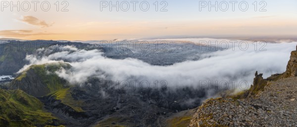Fog between the cliffs, clouds moving around, glacier ice of the Kötlujökull glacier tongue at