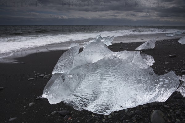 Little icebergs and crushed ice on the black beach at Joekulsarlon glacial lake