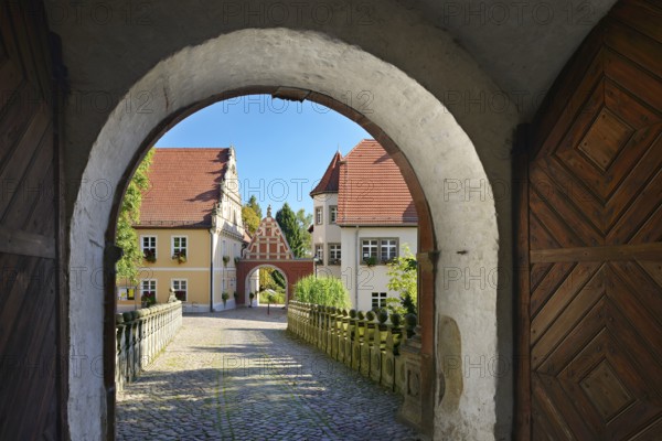 View through the castle gate of Wiesenburg Castle to the houses of the historic old town,