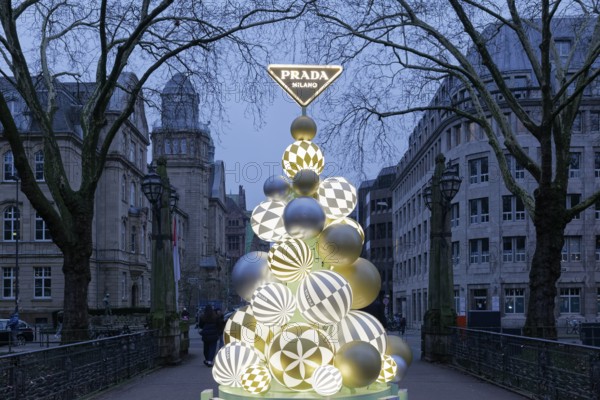 Designer Christmas tree of the Italian luxury brand Prada on a bridge over the Kö-Graben, twilight