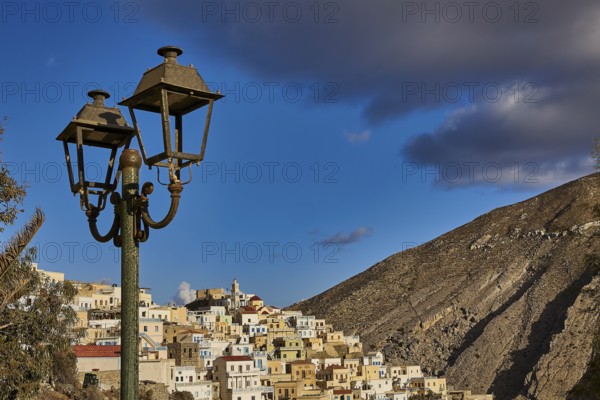 Old village in the mountains under a blue sky with streetlights in the foreground, Colourful