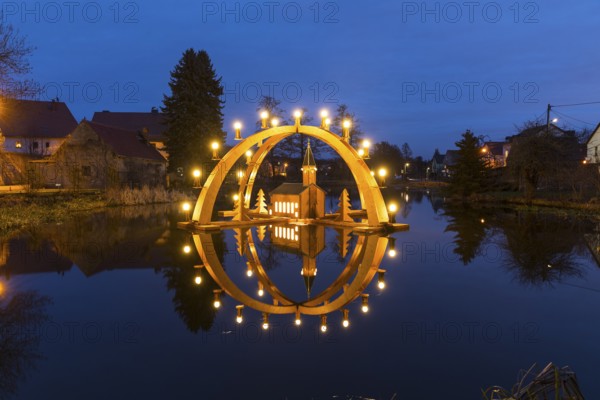 Floating double candle arch from the Ore Mountains with a model of the church on the village pond