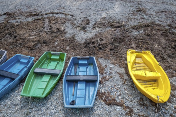 Pors Poulhan, Brittany, France - Colourful rowing boats moored on the harbour beach. The