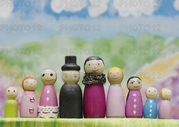 Nine funny painted wooden cones man and woman large and small in front of a colourful painted