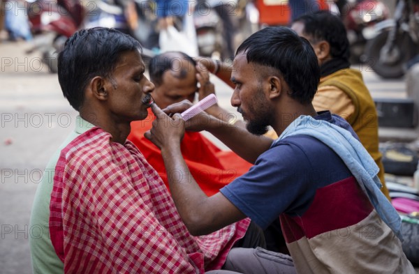 People shave in a street barber shop in Guwahati, India on 1 February 2025