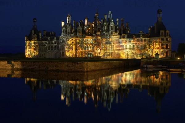 Chambord Castle with summer evening light show and moat, Chambord, Loir-et-Cher department, Centre