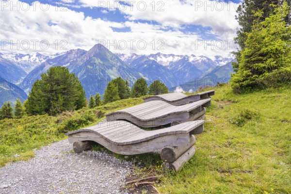 Wooden loungers on a mountain path offer a peaceful way to enjoy the surrounding landscape, Penken,